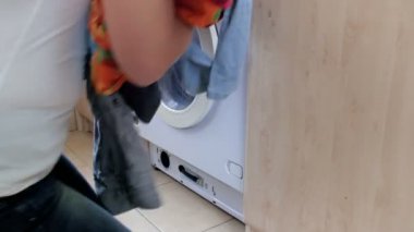 4 k görüntülerini giyim çamaşır makinesinde yükleme ve kapıyı kapatmaktan genç husewife