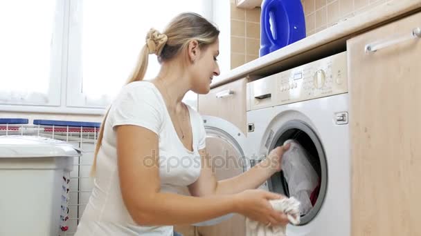 4k video of young woman made mistake by putting together different color clothes in washing machine — Stock Video