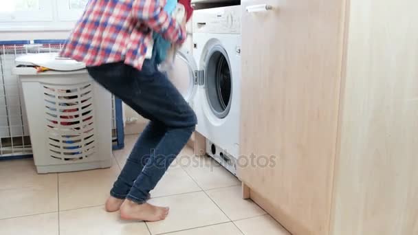 4k footage of teenage girl loading clothes in washing machine and turning it on — Stock Video