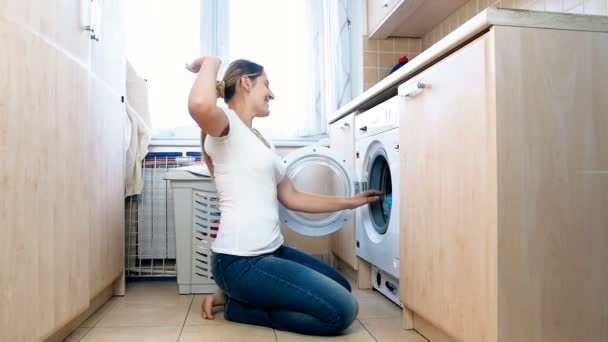 Filmagem em câmera lenta de feliz dona de casa alegre jogando roupas limpas na lavanderia — Vídeo de Stock