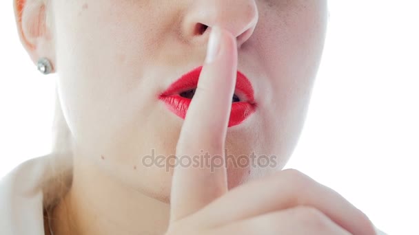 Closeup slow motion video of sexy young woman making silence gesture raising finger to lips — Stock Video