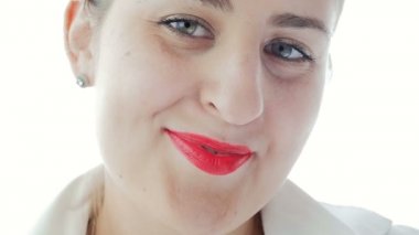 Ağır çekim video beyaz bluz kırmızı ruj kamera gülümseyen güzel genç kadın. Kamera defocuses yüzü üzerinden