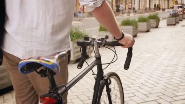 4k 的年轻时尚男子的镜头在欧洲城镇的旧街的固定齿轮运动自行车步行 — 图库视频影像