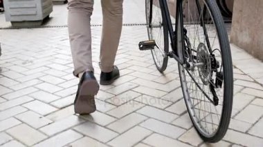 Vintage spor Bisiklet yanındaki sokakta yürüyen genç hipster adam görüntülerini düşük açılı