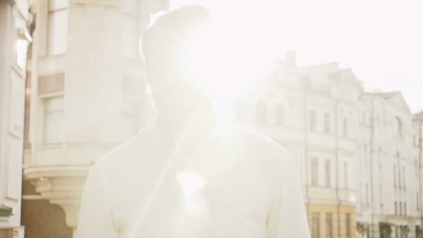 Повільний рух тоновані кадри впевненого стильного чоловіка з червоною бородою, що йде на вулиці на заході сонця — стокове відео