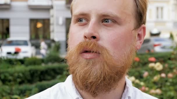 Zpomalené záběry z promyšlené hezký bearde muž kouření cigaret na lavičce v parku — Stock video