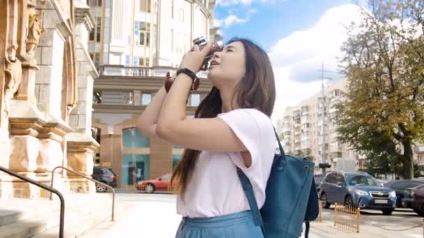 4k 的视频美丽的年轻女子制作照片与老式的老大教堂电影摄影机 — 图库视频影像