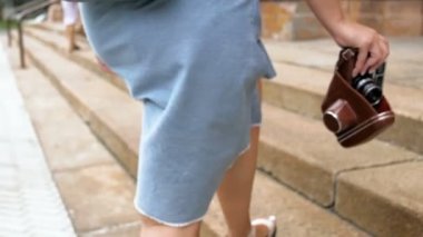 Ağır çekim portre video vintage film kamera ile yürüyen genç kadın