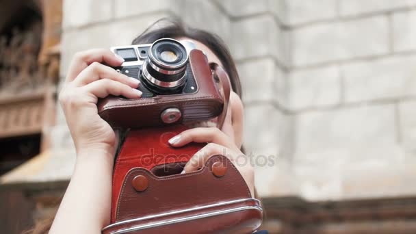 Toned closeup vídeo em câmera lenta de bela garota usando câmera de filme manual na rua — Vídeo de Stock
