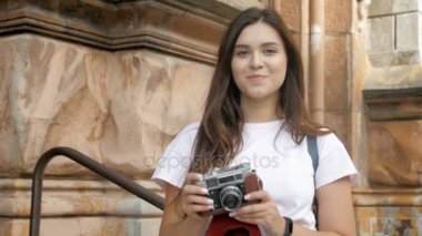 Gülümseyen, ağır çekim görüntüleri kamera seyir ve fotoğraf yapma uzun siyah saçlı turist kız