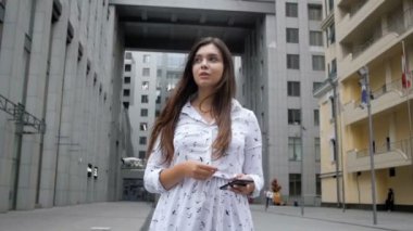Sokakta yürüyen ve hareket eden telefon tutarak endişeli genç kadın Slow motion video