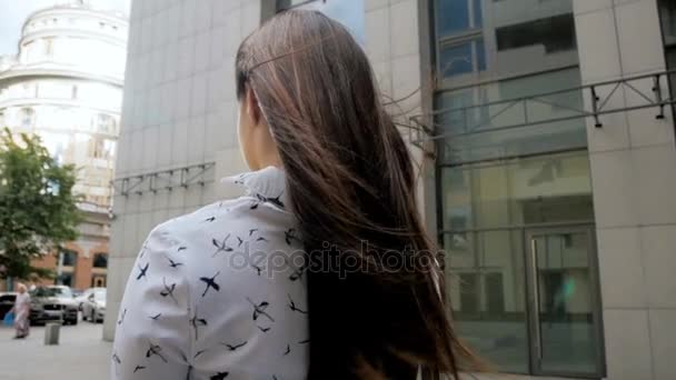 Mouvement lent de belle jeune femme aux cheveux longs faisant des photos de rue à la journée venteuse — Video