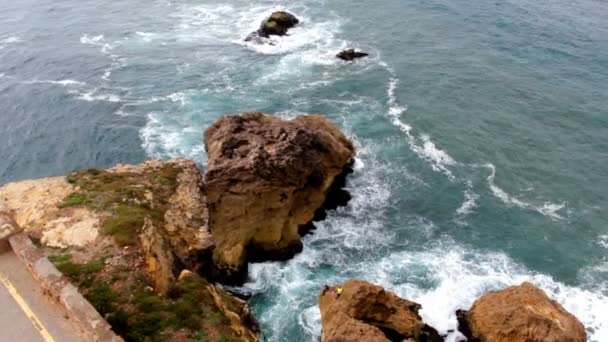 View from the cliff on ocean waves and rocks at shoreline — Stock Video