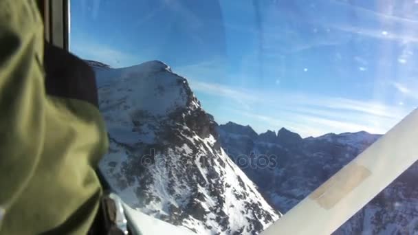 Imágenes de la cabina del avión de volar sobre altas montañas cubiertas de nieve — Vídeo de stock