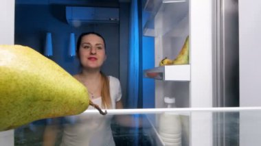 alarak ve armut buzdolabı gelen ısırma genç gülümseyen kadın 4 k video