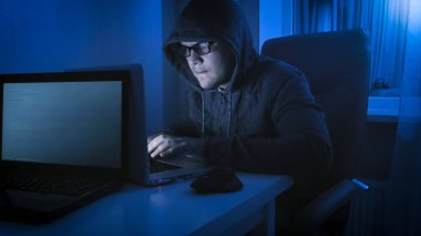 Bilgisayar üzerinde genç erkek siber suç çalışıyor gece portresi