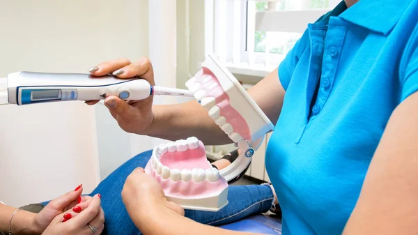 Close-up beeld van tandarts met behulp van kunststof kaak model om te informeren over de hygiëne van de tanden — Stockfoto