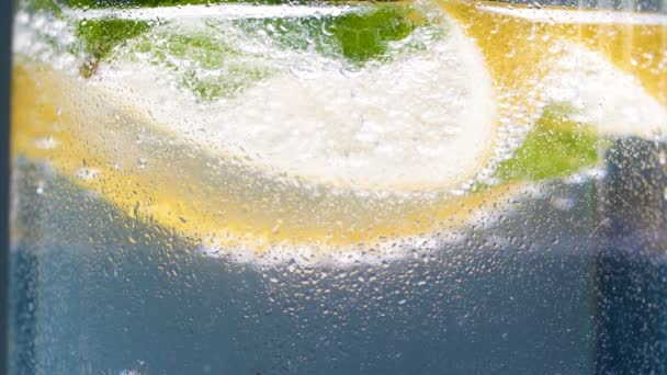 Macro 4k video of misty glass of cold lemonade with carbonated soda water — Stock Video