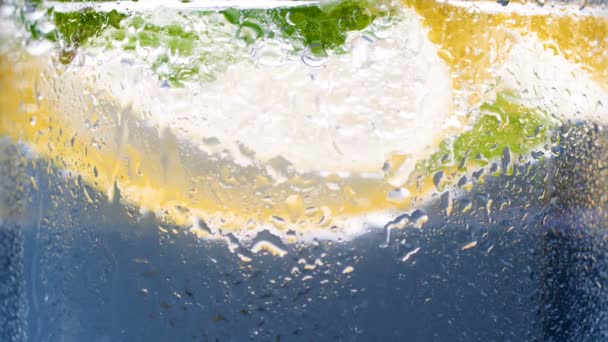 Closeup 4k footage of droplets of water flowing on misty glass of cold lemonade — Stock Video