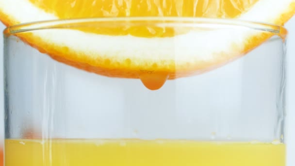 Крупный план 4k видео апельсинового сока капли падают в стекло — стоковое видео
