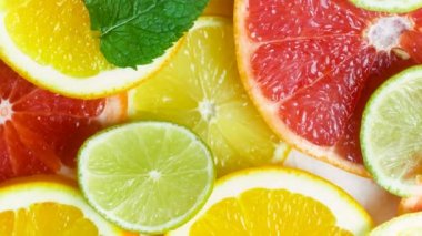 Limon, portakal, limon ve nane yaprakları ile greyfurt dilim boyunca hareketli kamera görüntülerini closeup 4k