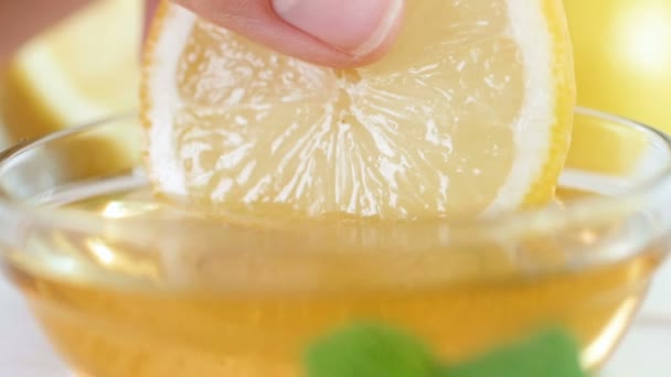 Closeup αργή κίνηση μήκος σε πόδηα του χέρι εμβάπτιση λεμονιού στο βάζο με μέλι στο πρωινό — Αρχείο Βίντεο