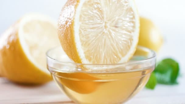 Замедленная съемка крупным планом вынимает лимонный ломтик из банки с медом — стоковое видео