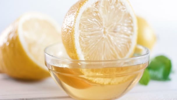 Крупный план замедленной съемки погружения в лимон и извлечения из стеклянной банки с медом — стоковое видео