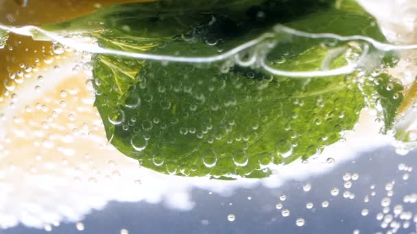Closeup slow-motion video van bubbels drijvend in glas koude limonade — Stockvideo
