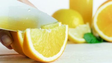 Ağır çekim görüntüleri el sulu portakal dilimleri büyük bıçak ile kesme.