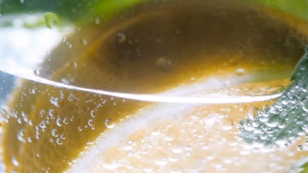 Macro footage of pouring carbonated water in glass of lemonade — Stock Video