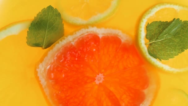 Gros plan ralenti vidéo de tranche de citron tombant dans un pot de jus d'orange frais — Video