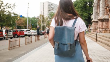 Sokakta yürüyüş çanta ve Vintage Film kamera ile genç kız arka görüş görüntüsü