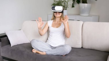 VR giyen koltukta oturan mutlu heyecanlı kadın gözlüğü