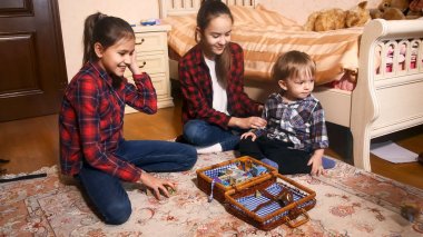 Küçük kardeşim yatak ile oynarken iki gülümseyen kız kardeş