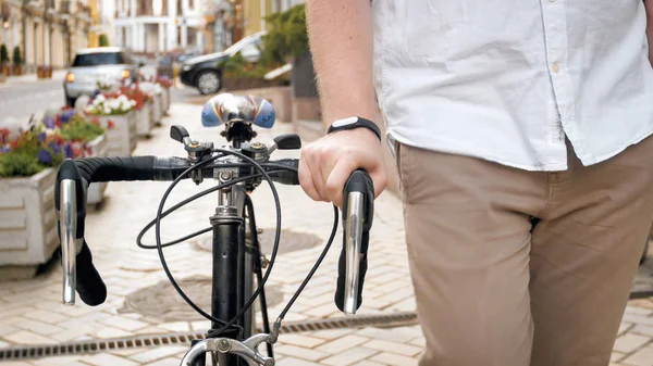 自転車で通りを歩くフィットネス トラッカー ブレスレットを身に着けているスタイリッシュな男のクローズ アップ画像 — ストック写真