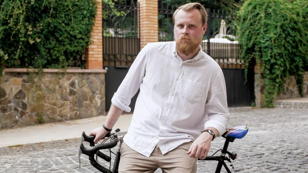Портрет стильного бородатого мужчины, позирующего с винтажным велосипедом — стоковое фото