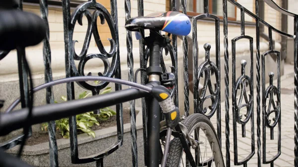 Photo rapprochée de vélo vintage verrouillé à une clôture métallique dans la rue — Photo