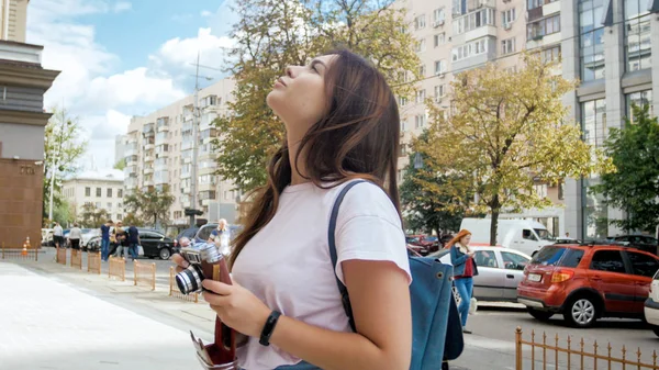 Portrait of beautiful tourist girl with camera and bag on street — Stock Photo, Image