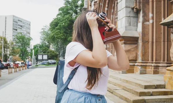 Hermosa chica turista morena haciendo imagen de la antigua catedral en la cámara de cine vintage —  Fotos de Stock