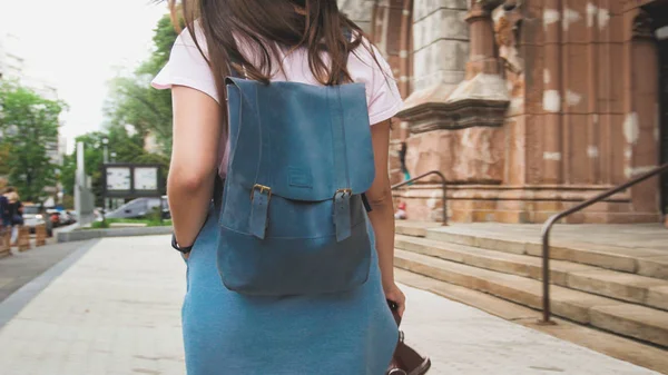 Rear view image of stylish tourist girl with bag walking on old street — Stock Photo, Image