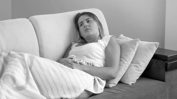Черно-белый образ больной женщины лежащей в постели — стоковое фото