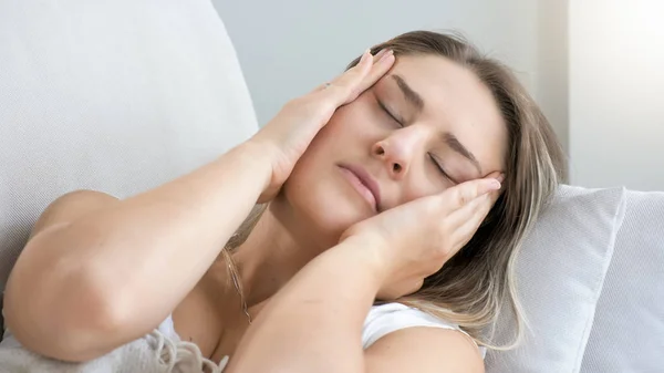 Closeup portrait of young woman suffering from migraine holding hands on head — Stock Photo, Image