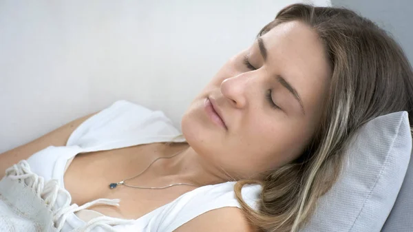 Portrait of young woman feeling sick lying on sofa at living room — Stock Photo, Image