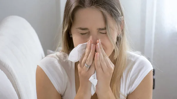Портрет крупным планом чихающей больной женщины дома — стоковое фото