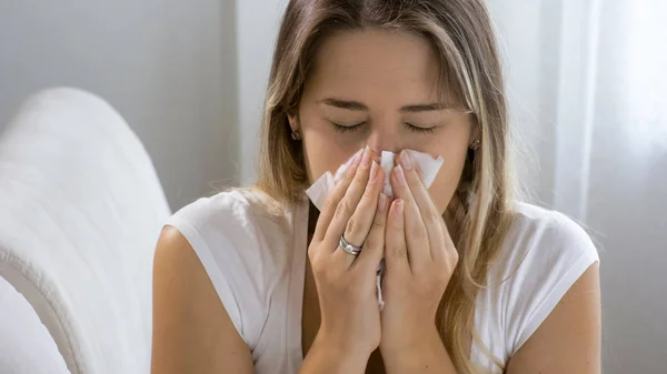 Portrait of sneezing woman in paper tissue — Stok Foto