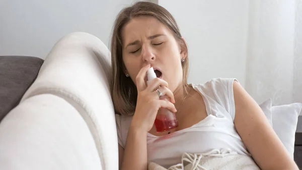 Retrato de una joven enferma con aerosol en la garganta — Foto de Stock