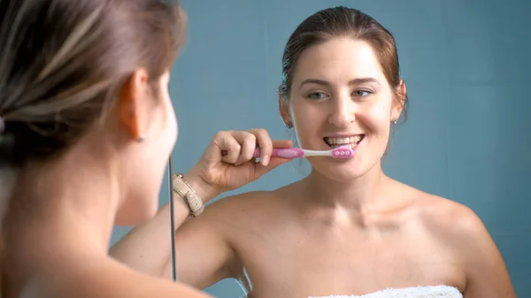 Foto einer glücklich lächelnden Frau beim Zähneputzen im Badezimmer — Stockfoto