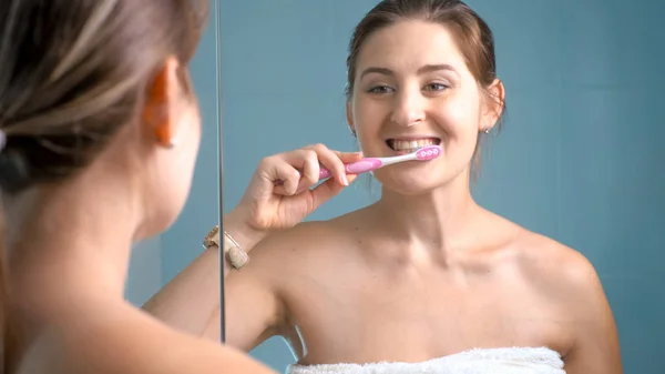 Porträtt av glada leende ung kvinna borsta tänderna på morgonen — Stockfoto