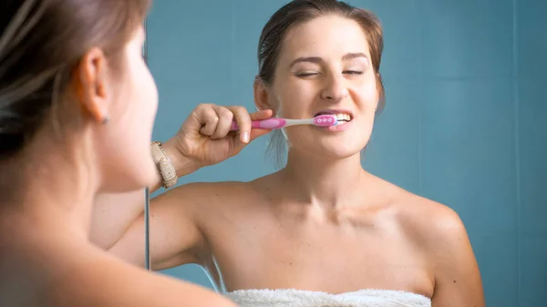 Jovem morena sonolenta escovando os dentes de manhã — Fotografia de Stock